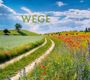 2027 WEGE PATHS CHEMINS. Ein Feldweg zwischen grünen Feldern und farbenfrohen Blumen, unter einem blauen Himmel.