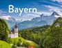 Text: "Bayern 2027" und "WENGARTEN". Eine malerische Kirche auf einem Hügel mit Alpen im Hintergrund.