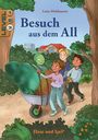 "Besuch aus dem All", Luise Holthausen, Level 1-3. Drei Kinder schieben einen Außerirdischen in einer Schubkarre im Wald.