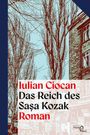"Iulian Ciocan, Das Reich des Sașa Kozak, Roman" in roten und schwarzen Lettern. Illustration mit kahlen Bäumen und Gebäude.