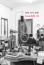 Text: "eins zwei drei, Cose della vita". Unschärfer Raum mit mehreren Schreibtischlampen und Regalen im Hintergrund.