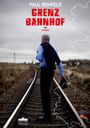 „PAUL REHFELD GRENZ BAHNHOF ROMAN“ in großen Buchstaben. Ein Mann auf einer leeren Eisenbahnstrecke, hält Hut.
