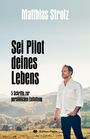 Text: „Matthias Strolz“, „Sei Pilot deines Lebens“, „5 Schritte zur persönlichen Entfaltung“. Ein Mann steht auf einem Feld.