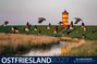 Text: "OSTFRIESLAND 2027", "Mit 6 Ansichtskarten". Abendstimmung mit fliegenden Gänsen und Leuchtturm im Hintergrund.