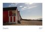 „Dreams 2027” und „Southend on Sea“ sind sichtbar. Strandhäuschen in Rot-Weiß am sonnigen Kiesstrand.