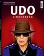 "UDO LINDENBERG GEBURTSTAGSEDITION" steht vorne; Porträt eines Mannes mit Hut und Sonnenbrille, dunkelroter Hintergrund.