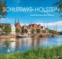 „SCHLESWIG-HOLSTEIN 2024. Land zwischen den Meeren.“ Boote vor einer Altstadt mit Backsteinhäusern, Wasser im Vordergrund.