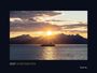 2027 HURTIGRUTEN. Ein Schiff segelt vor einer Bergkulisse bei Sonnenuntergang.
