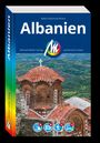 Titel „Albanien“ von Ralph-Raymond Braun. Im Hintergrund eine alte Kirche mit roten Ziegeldächern.
