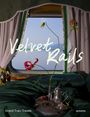 „Velvet Rails“ steht groß auf einem Fenster. Ein Teeservice und Blumen vor grünen Vorhängen in einem Zugabteil.