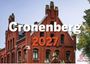 Text: "Cronenberg 2027". Hintergrund: Rotes Backsteingebäude mit spitzen Dächern. Unten rechts ein stilisiertes Löwenlogo.