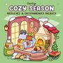 Text: "Coco Wyo Cozy Season Niedliches & Entspannendes Malbuch."  
Illustration: Bequemer Raum mit Kamin, Sessel, Decken.
