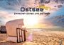 "Ostsee 2027. Zwischen Dünen und Horizont." Ein Strandkorb steht am sonnigen Sandstrand, der Himmel zeigt lebendige Farben.
