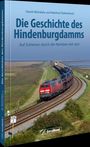 „Die Geschichte des Hindenburgdamms“ von Daniel Michalsky und Manfred Diekenbrock. Zug fährt durch Marschlandschaft.