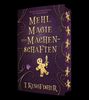 „MEHL, MAGIE UND MACHENSCHAFTEN“ steht in großen goldenen Buchstaben. Es zeigt einen Lebkuchenmann mit Messer.