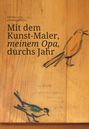 „Mit dem Kunst-Maler, meinem Opa, durchs Jahr“ steht auf Holz mit gezeichneten Vögeln in Schwarz und Orange.