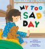 "MY TOO SAD DAY" in bunten Buchstaben. Ein Kind im blauen Schlafanzug mit Punkten sitzt mit einem Plüschtier auf dem Bett.