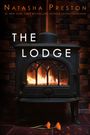 „THE LODGE“ steht groß über einem brennenden Kaminofen, davor liegen zwei orange Blumen und Blütenblätter.