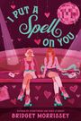 "I Put A Spell On You" in großen Buchstaben, zwei Personen sitzen mit Rollschuhen unter einer Discokugel, rosa Herzen.