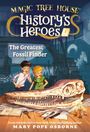 Ein Junge und ein Mädchen betrachten lächelnd einen großen Dinosaurierschädel auf einem Tisch. Bücher und Werkzeuge liegen herum.