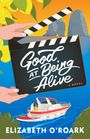 „Good at Being Alive“ auf einer Filmklappe, darunter ein Boot mit einem Paar vor Felsen und Zitronen.