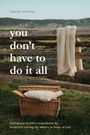 „You don’t have to do it all.“ Ein Korb mit Decke vor einem Holzzaun in ländlicher Landschaft.
