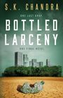 Text: "S.K. Chandra, One Last Drop, Bottled Larceny, One Final Heist". Illustration: Trockene Erde, zerknickte Plastikflasche, Stadt im Hintergrund.